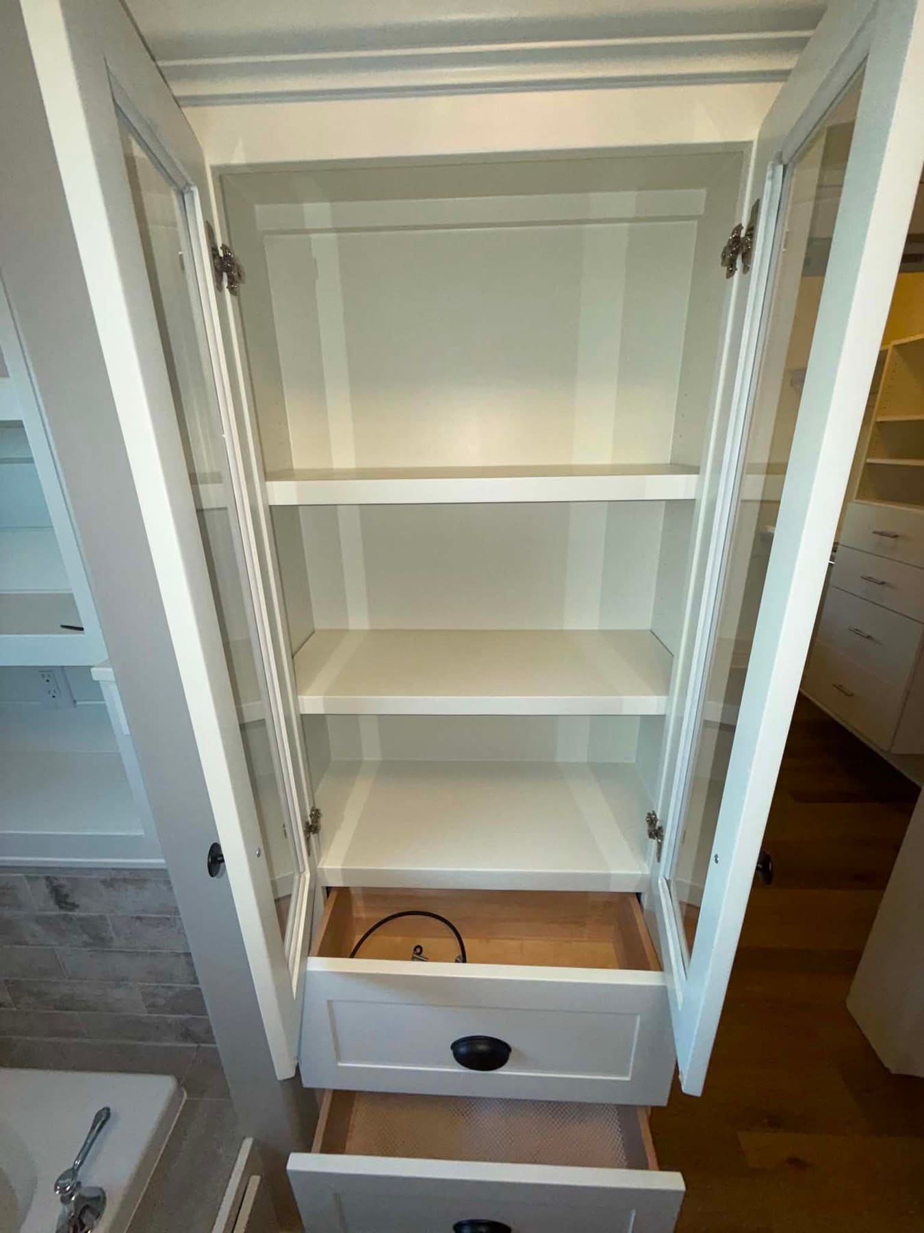 Linen cabinet with clean shelves and drawers, emptied for cleaning
