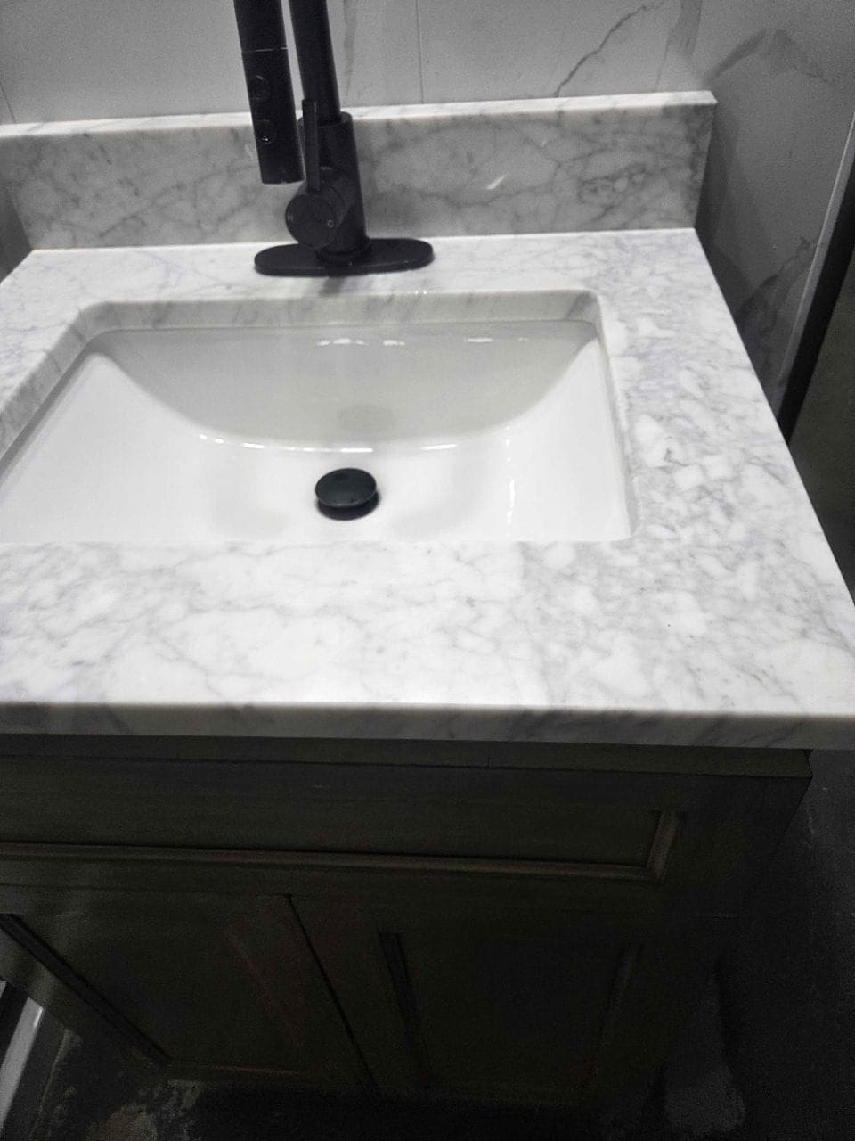 Marble-look vanity top with a white rectangular sink, wiped clean