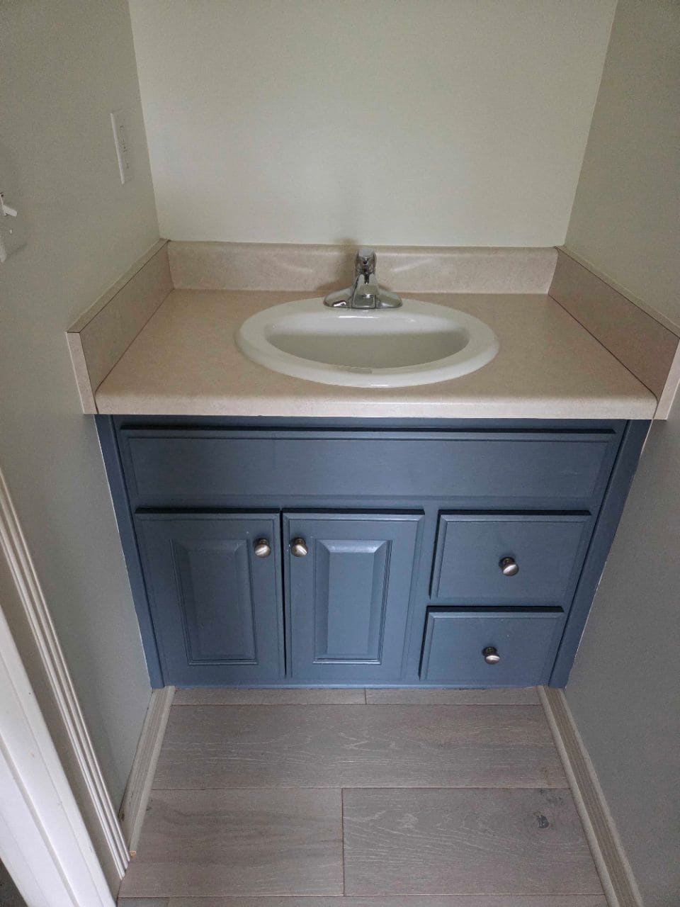 Small bathroom with a navy vanity and a round sink, cleaned