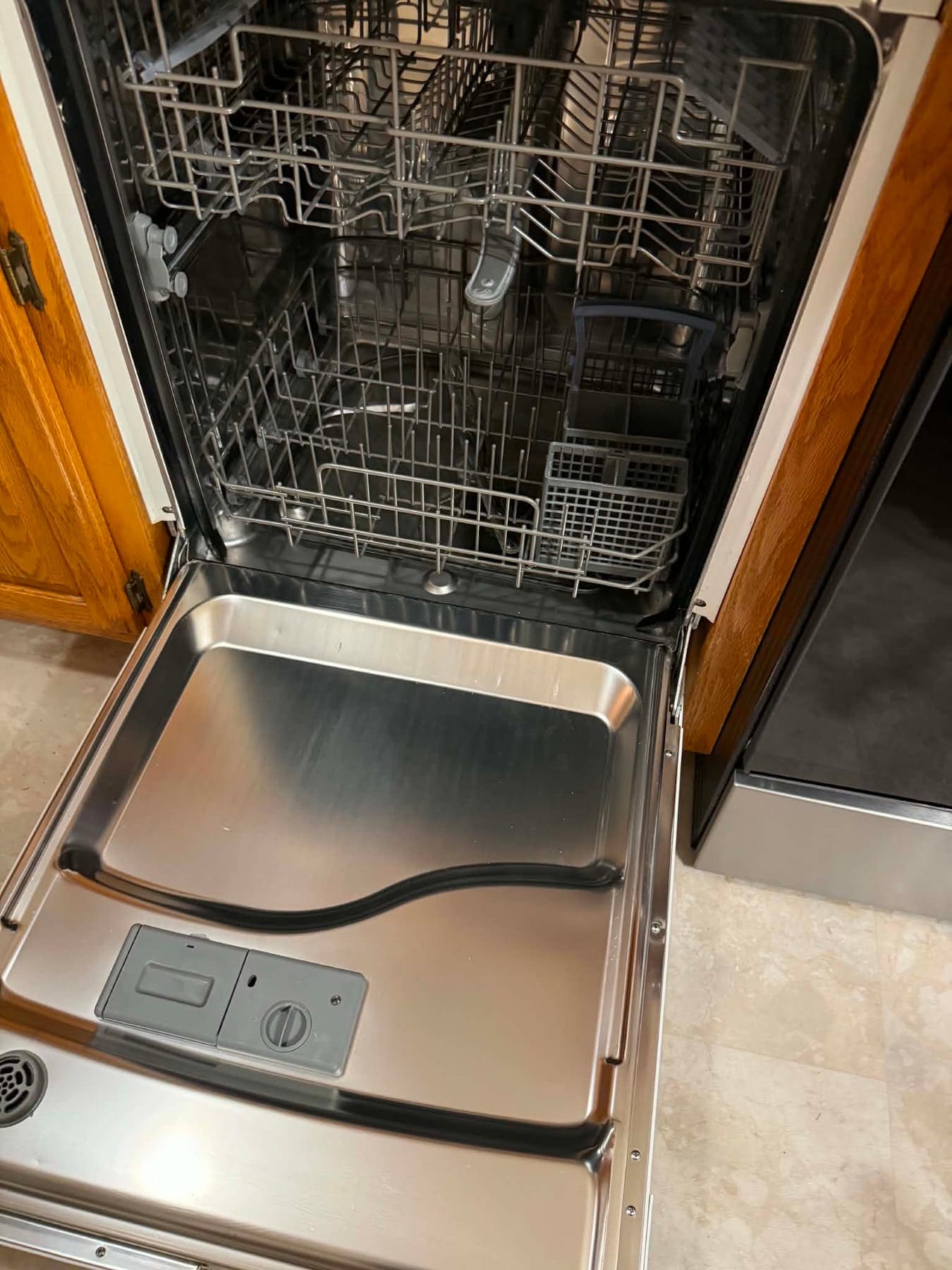 Open dishwasher with a clean tub, rack, and door