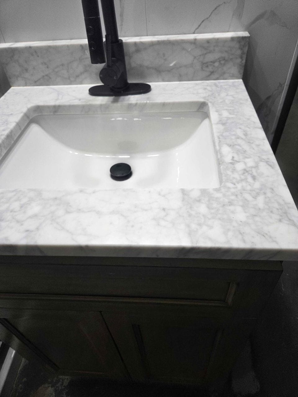 Marble-look vanity top with a white rectangular sink, wiped clean