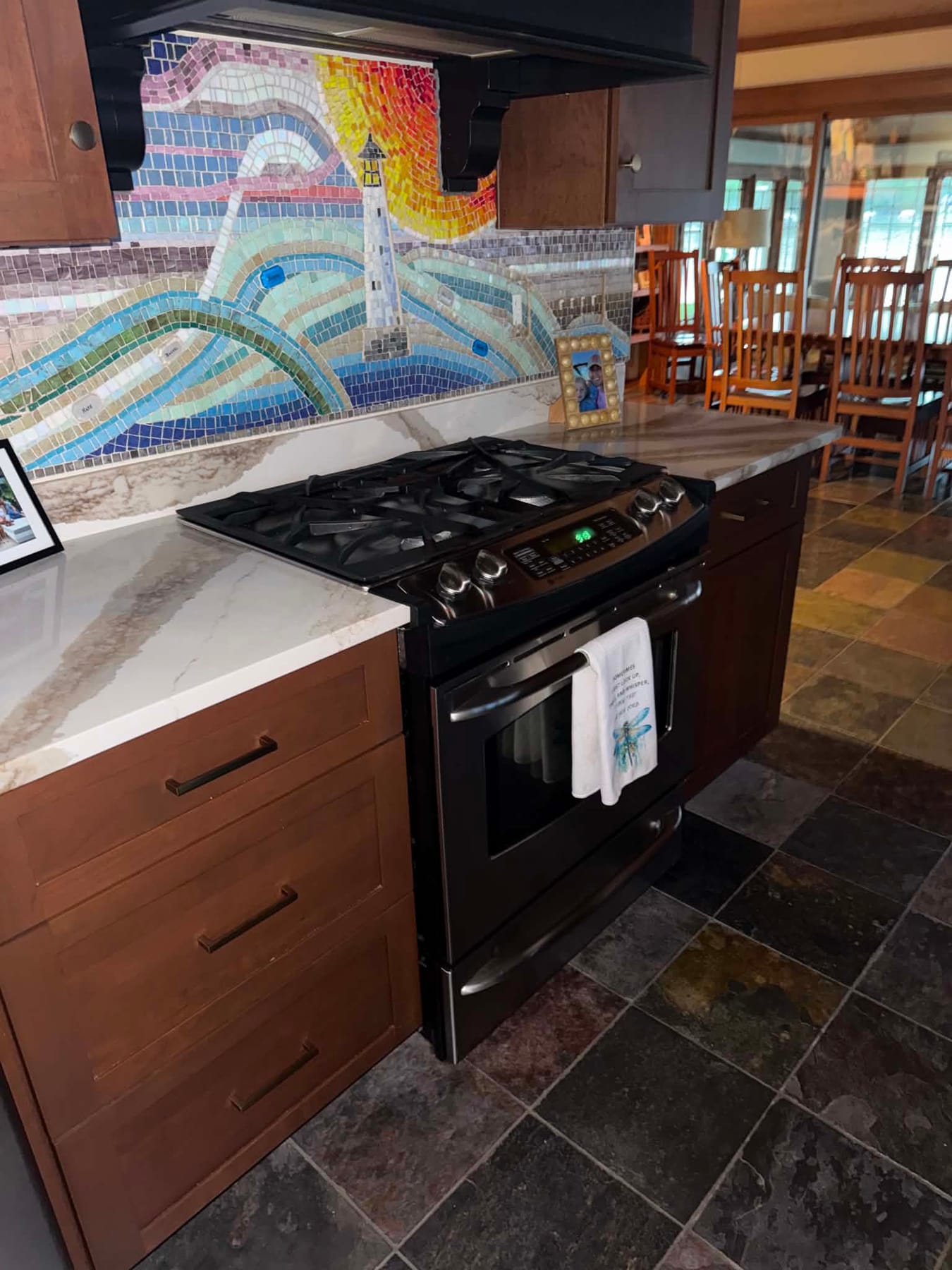 Gas range with a colorful mosaic backsplash and wood cabinets, cleaned