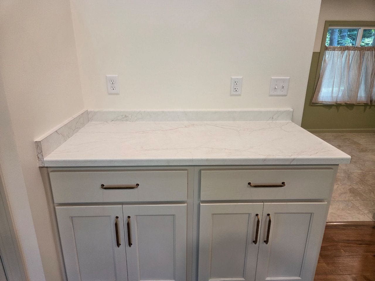 White kitchen cabinets under a light counter, wiped clean